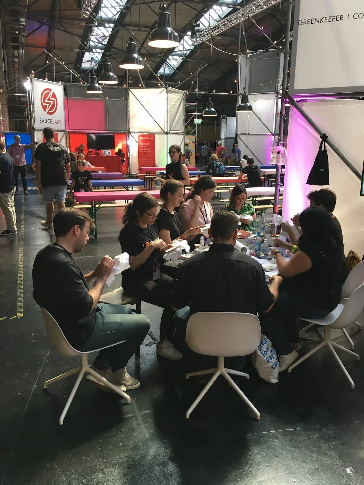 A bunch of people at the Neighbourhoodie embroidery table at JSConf EU 2019